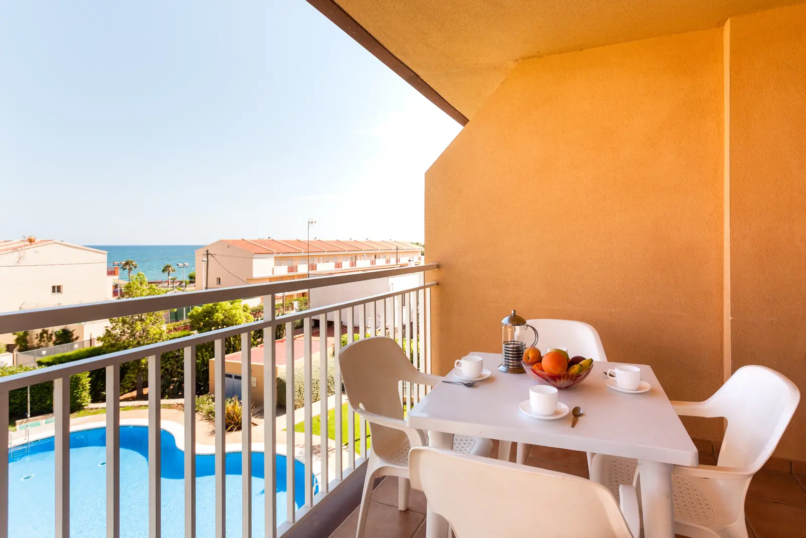 Terrasse einer Ferienwohnung Bovalar mit Tisch und Blick auf Pool und Meer in Alcossebre